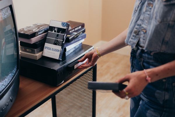 An old VHS tape palyer with a few tape stacked on top.
